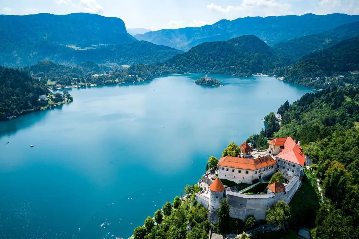 Lake Bled Castle overlooking turquoise lake with island church and Julian Alps in background