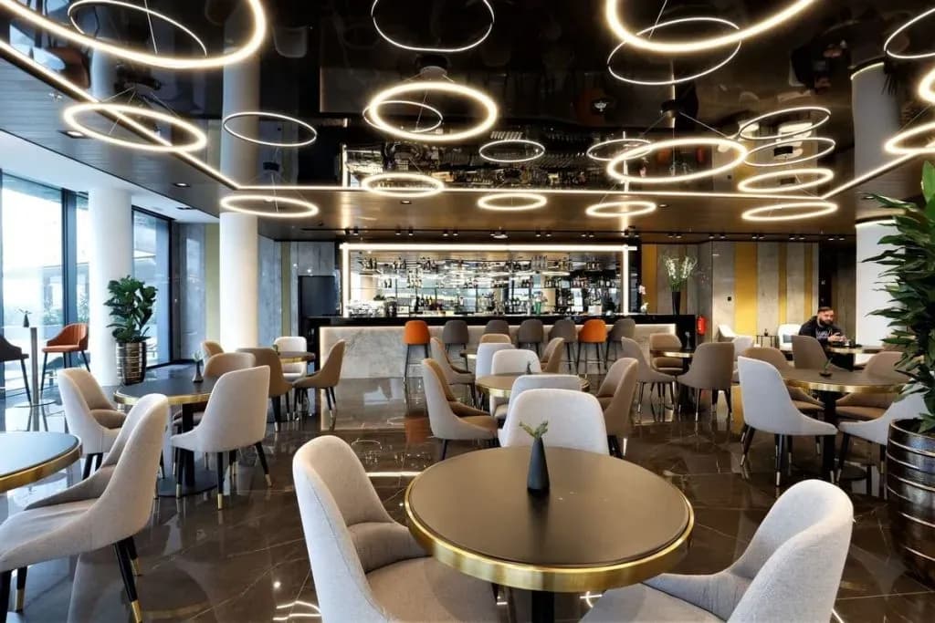 Modern lounge interior with circular lighting, plush seating, and a well-stocked bar area