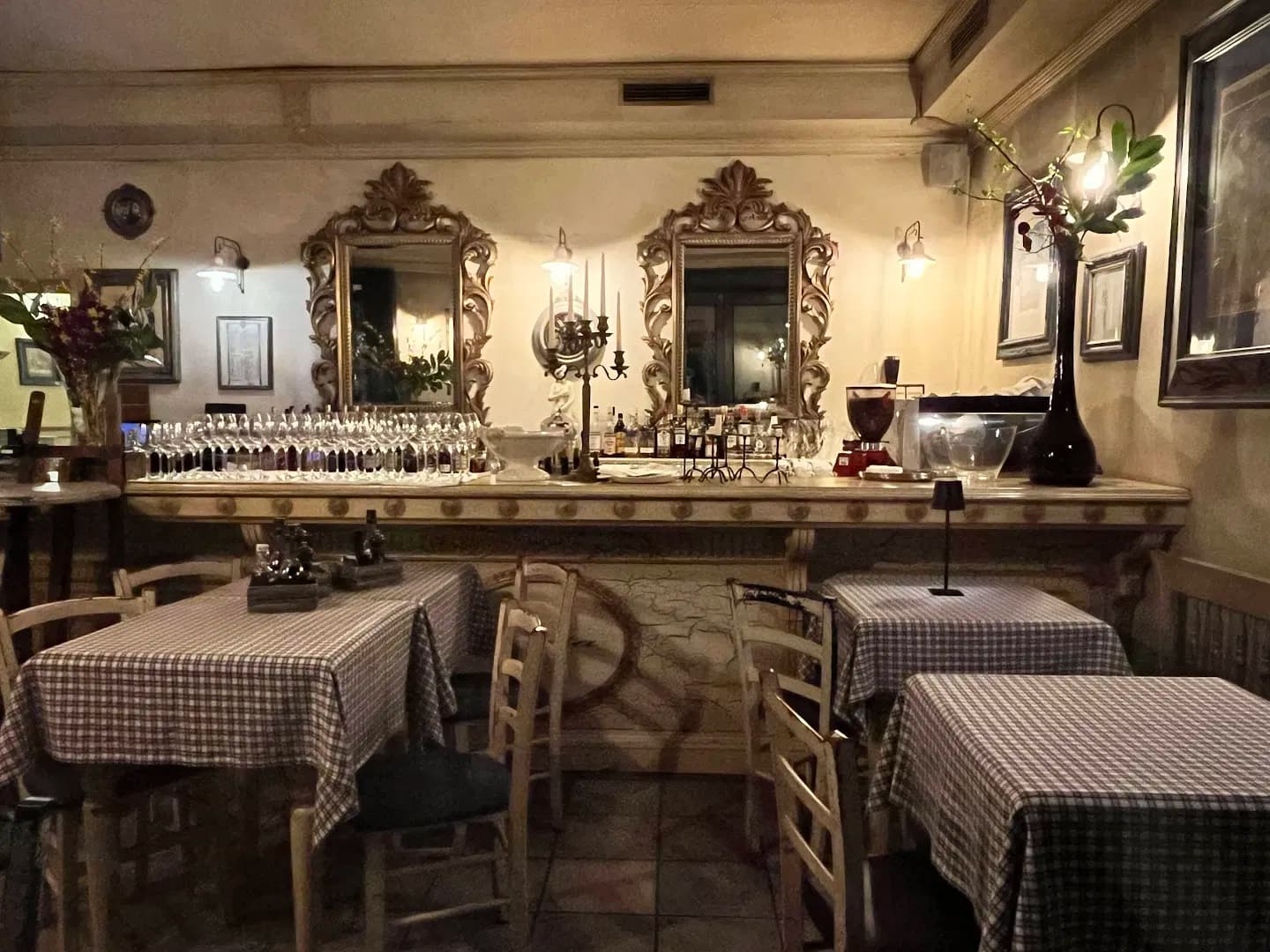 Interior of Julija Restaurant with dining tables and a bar displaying wine glasses and ornate mirrors.