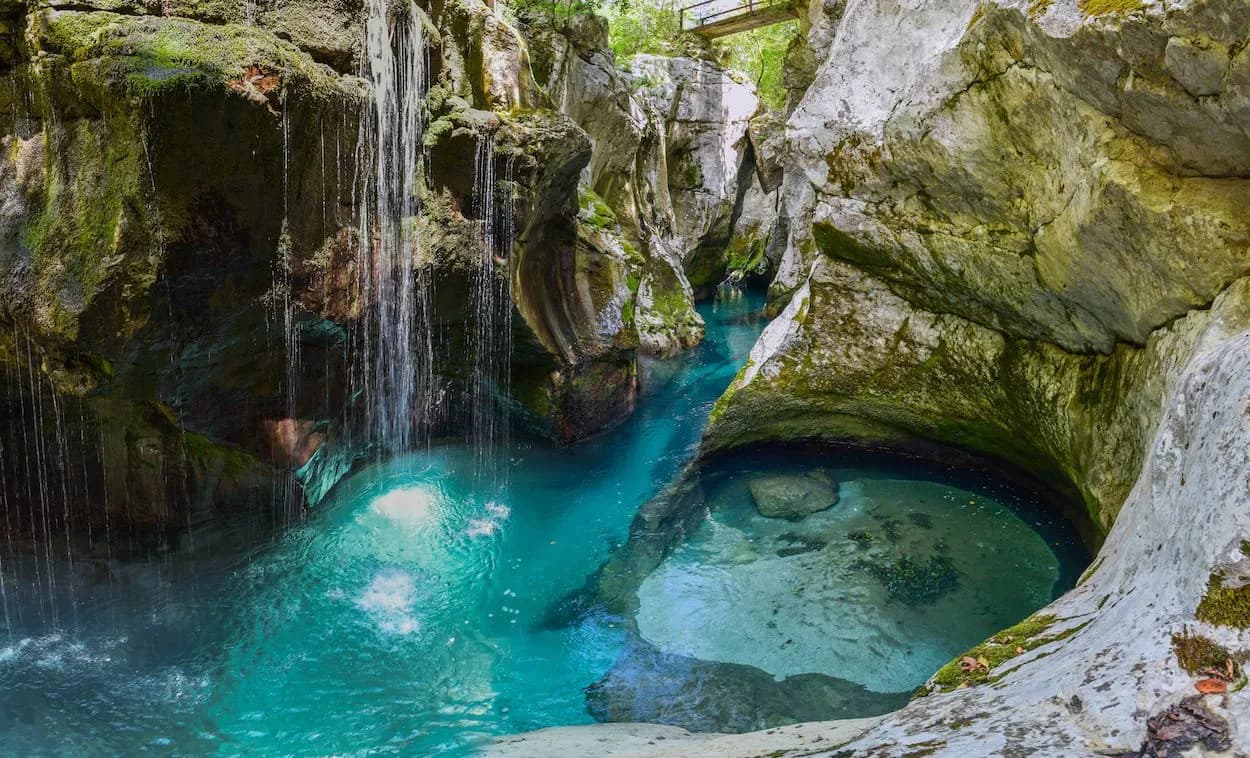 Soca canyoning with turquoise water, waterfalls, and mossy rock formations