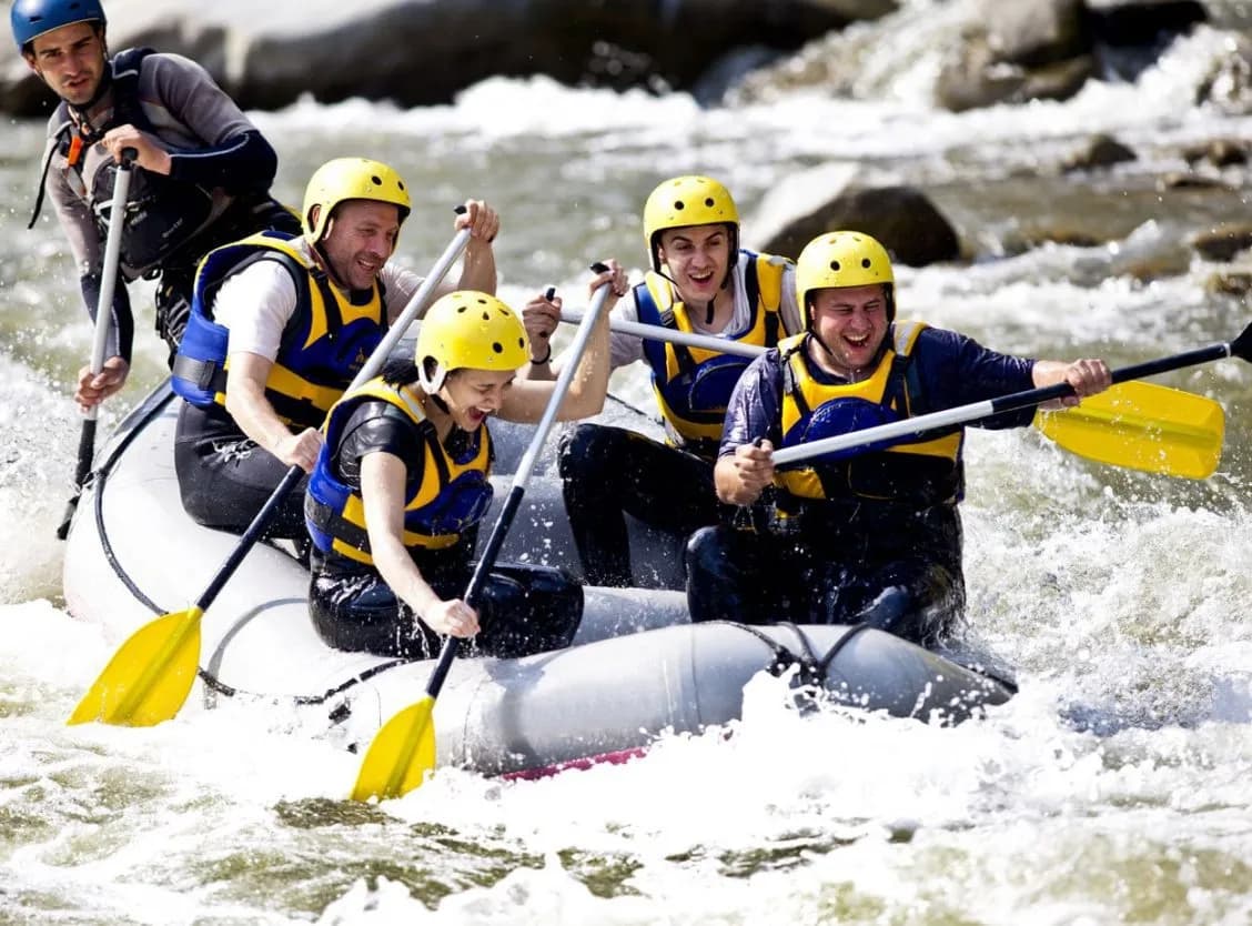 Group whitewater rafting with paddles on the Soca River.