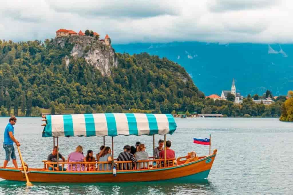 Pletna boat ride on Lake Bled with Bled Castle on a cliff in the background