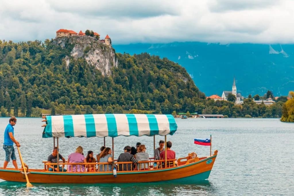 Pletna boat ride on Lake Bled with Bled Castle on a cliff in the background