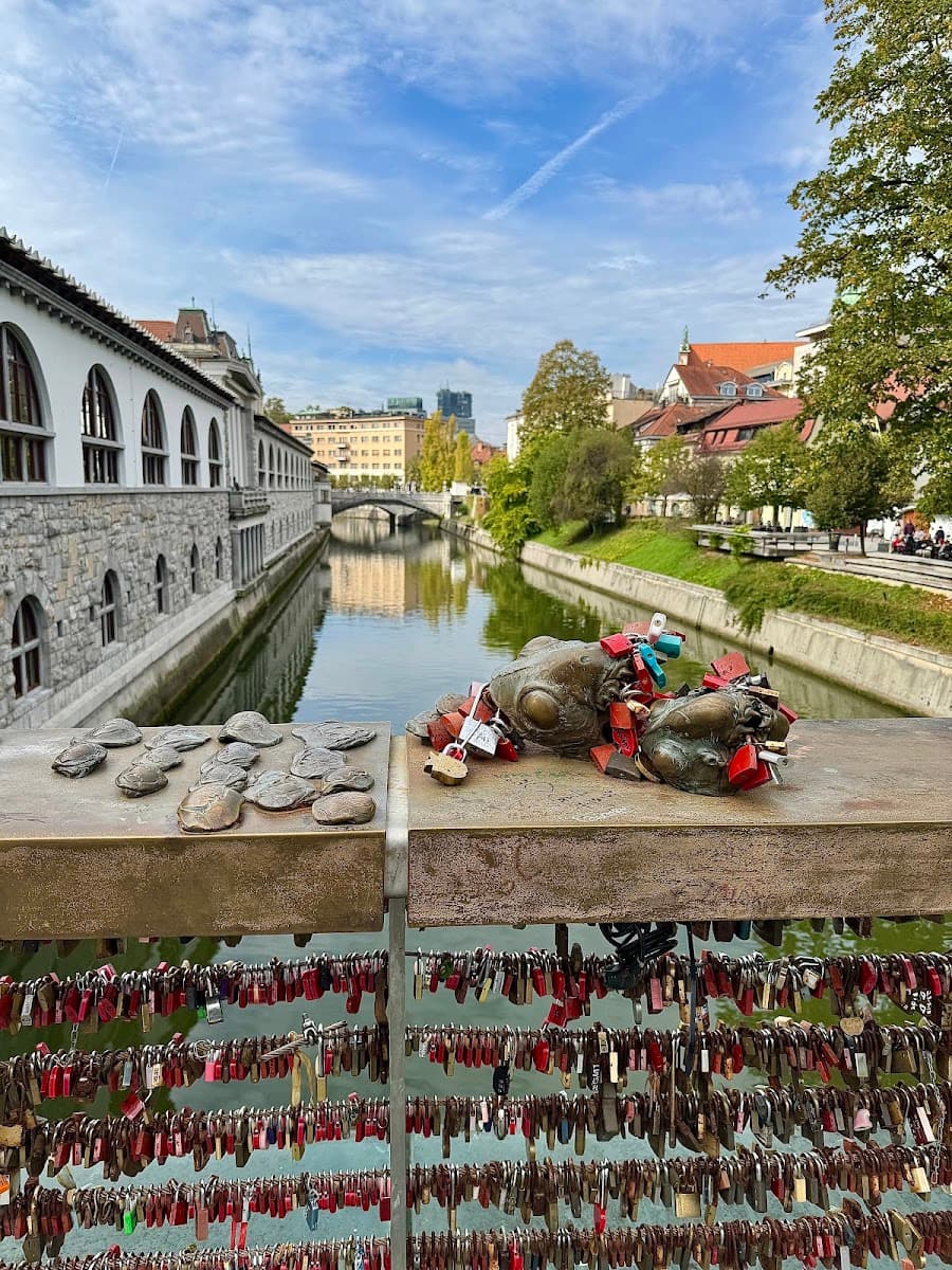 Frog statues with love locks on bridge railing over river in Ljubljana, Slovenia