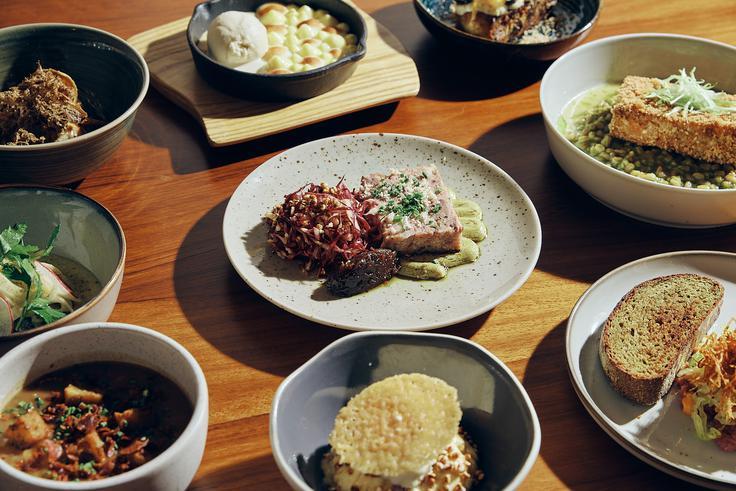 Assortment of gourmet dishes and desserts served on a wooden table at Georgie Bistro