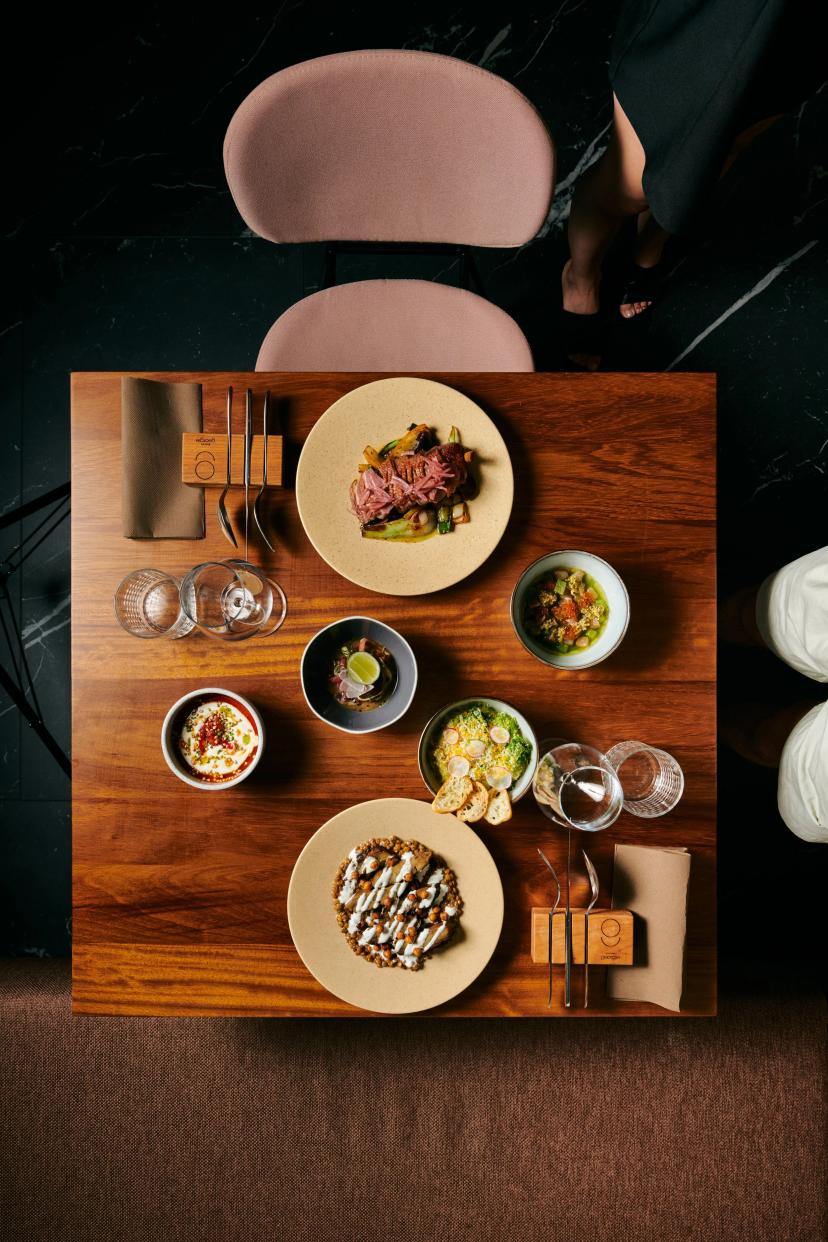 Overhead view of multiple gourmet dishes served on a wooden table at Georgie Bistro.