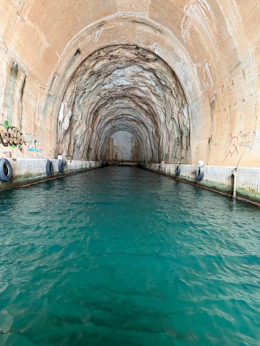 Underground boat tunnel with turquoise water and concrete walls