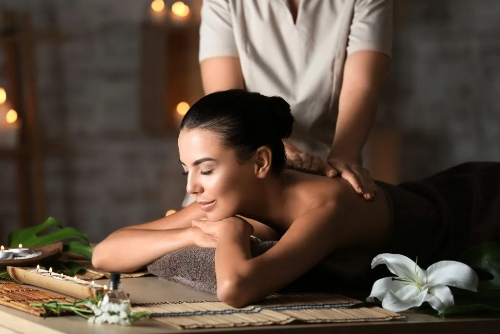 Hermosa mujer joven recibiendo masajes en el salón de spa